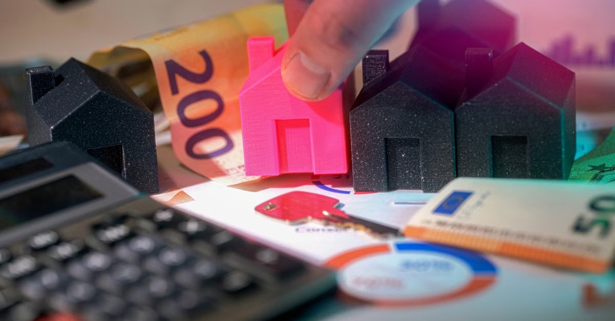 Taschenrechner und Modellhaus zur Berechnung des Immobilienbudgets
